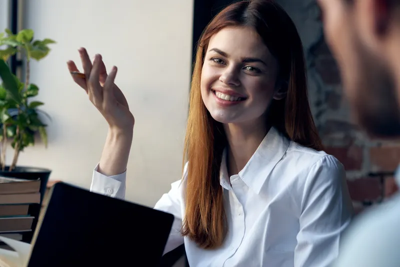 Женщина рядом с мужчиной, коллеги общаются и веселятся