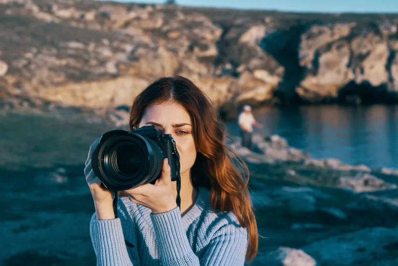 Женщина-туристка, фотограф, профессиональный снимок на фоне скалистых гор и природы