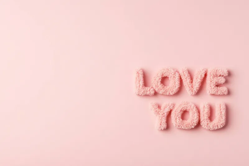 Этот очаровательный розовый пушистый текст «LOVE YOU» демонстрирует игривый дизайн на мягком пастельном фоне, идеально подходящий для романтических тем и сердечных посланий