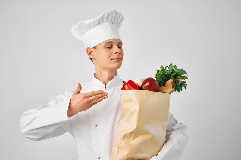 Шеф-повар с упаковкой свежих продуктов занимается приготовлением еды