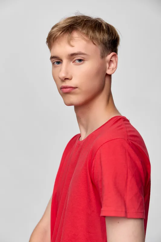 Young man, model, casual fashion, red shirt, studio shot, male, confident expression for fashion imagery with clean backdrop and minimalist styling suitable for apparel catalogs.