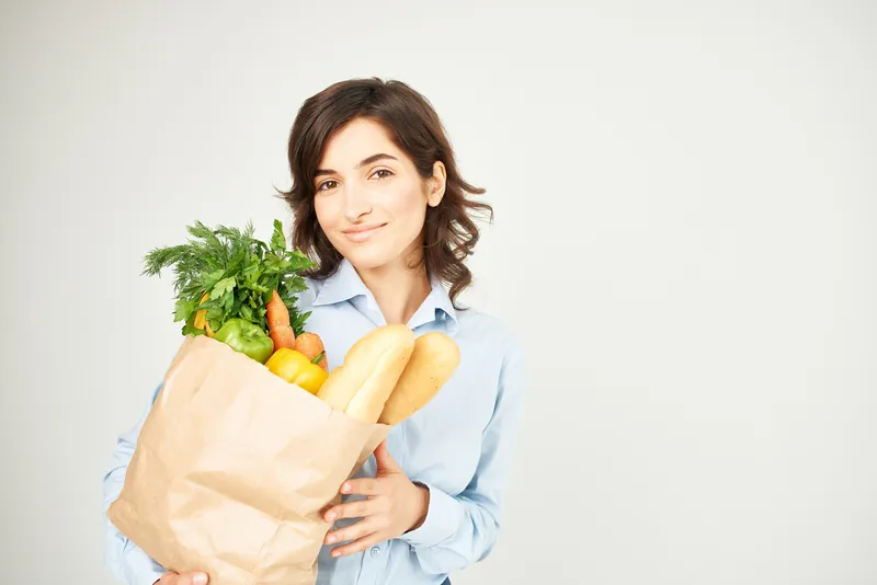 Женщина с бумажным пакетом продуктов в супермаркете, образ жизни