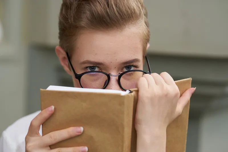 Привлекательная женщина с книгой в руках на открытом воздухе, читает