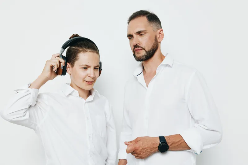 Male business professionals pose against a clean, isolated colored background, showcasing focus and confidence with listening engagement and a thoughtful expression.