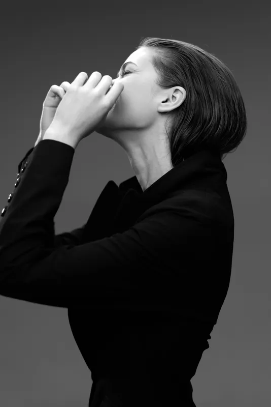 Black and white portrait of a thoughtful woman in jacket expressing deep emotion and contemplation.