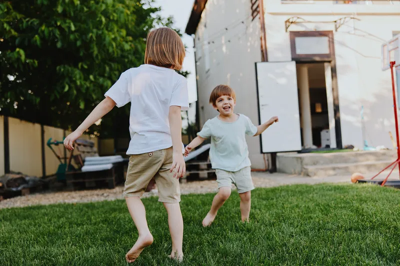 Happy boys playing together in the garden, enjoying a sunny day and making joyful memories with laughter and excitement. A perfect capture of childhood happiness.
