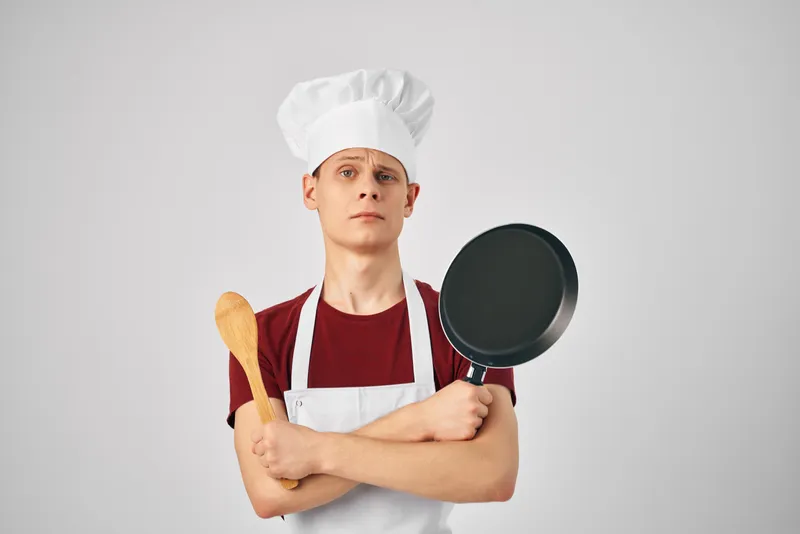 Мужчина-шеф-повар с кухонной утварью, приготовление еды в ресторанах