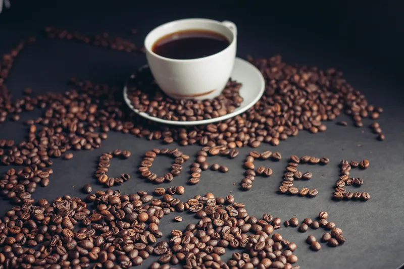 Чашка кофе для завтрака и надпись «arabica» на столе