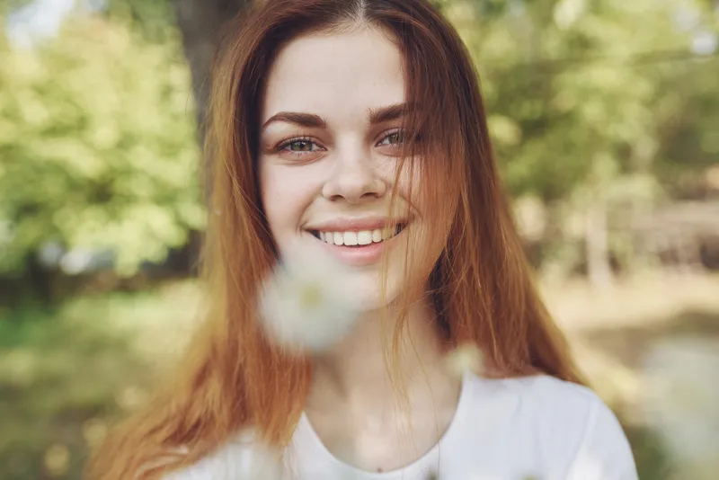 Весёлая женщина с цветами в руках