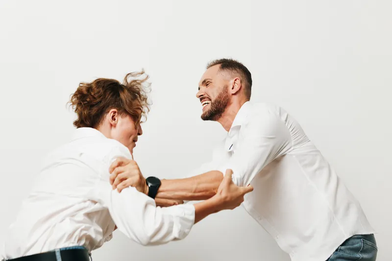 Theme: business man professional emotion. A dynamic pair of men in white shirts interact with energy against an isolated white background, conveying focus, determination, and confident teamwork.