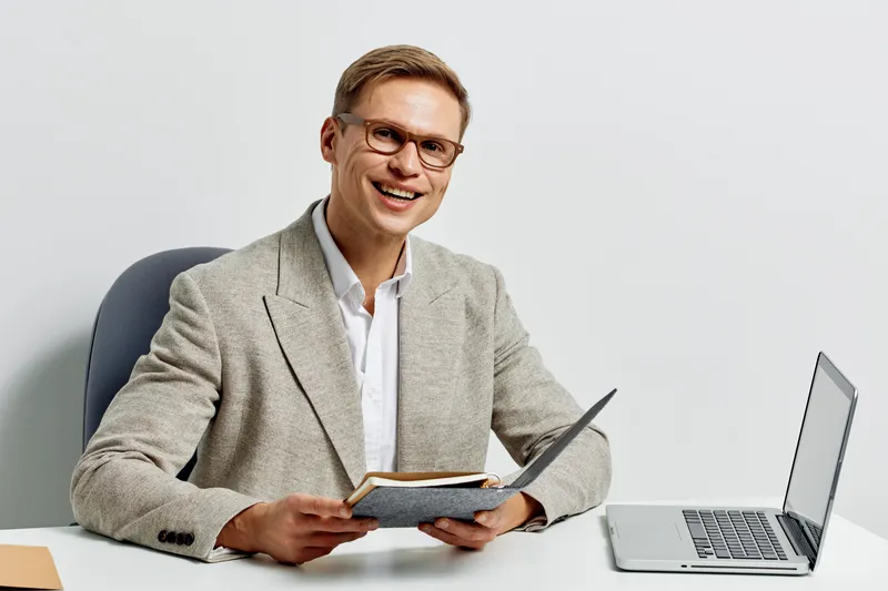 smiling man working with laptop and notebook digital nomad remote freelance communication concept