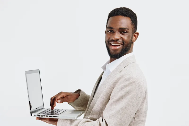 Smiling man using laptop, casual business attire, light background, professional, confident, modern style, technology, work from home, Entrepreneurship, in-office environment. People lifestyle concept