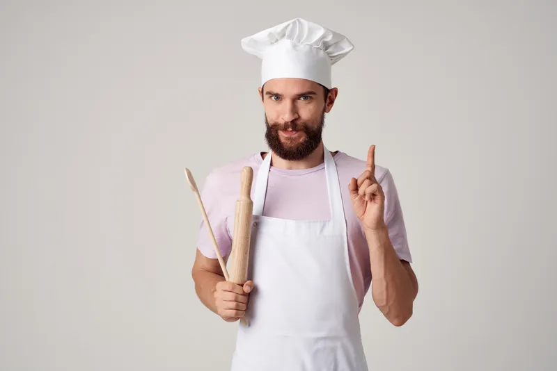 Мужчина-повар в фартуке на кухне ресторана высокой кухни, профессиональное приготовление еды