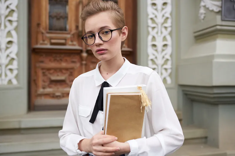 Студент на улице возле здания отдыхает, ведёт размеренный образ жизни