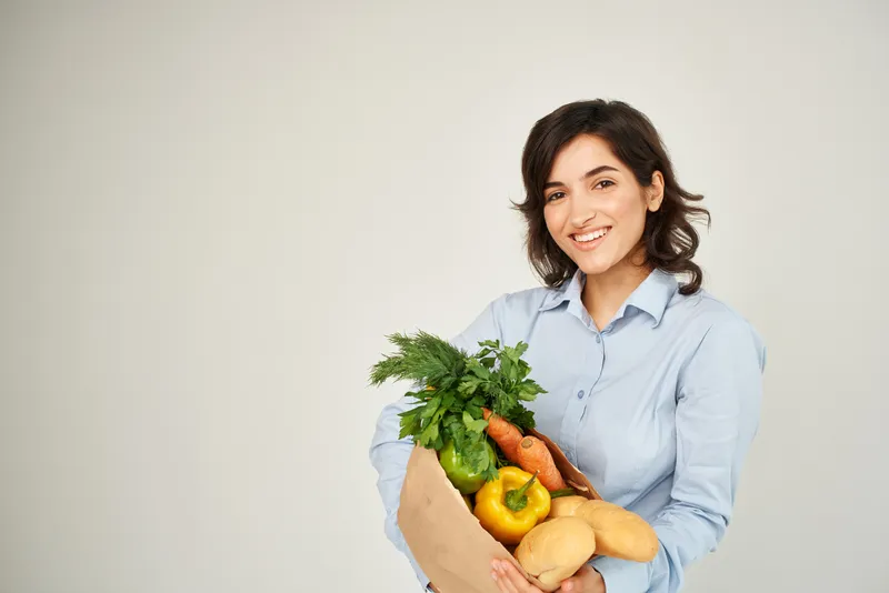 Весёлая женщина с пакетом продуктов, овощей, здоровой еды