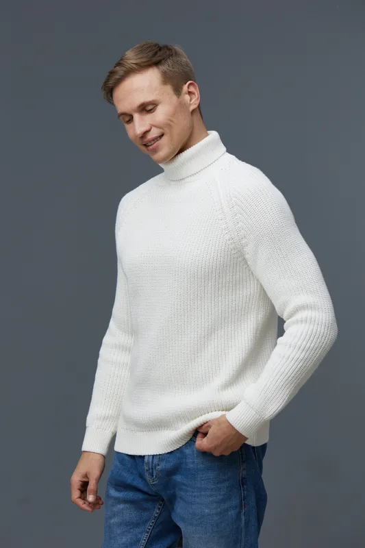smiling young caucasian man wearing white knitted turtleneck sweater standing look down pose casual style gray background mental health and gadgets concept