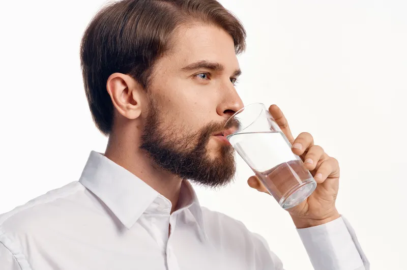 Красивый мужчина заботится о здоровье, чистая вода, студия