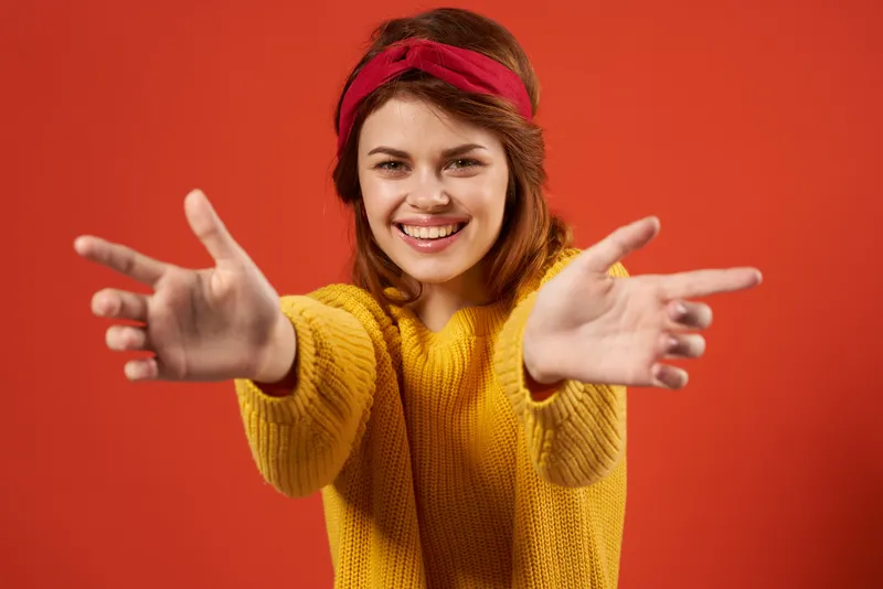 Симпатичная женщина в красной повязке на голове и жёлтом свитере в стиле хипстер