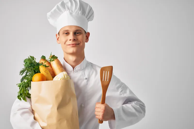 Шеф-повар с упаковкой свежих продуктов занимается приготовлением еды