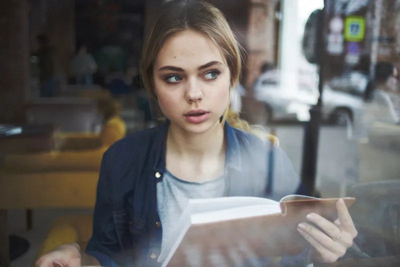 Женщина с книгой отдыхает утром, общается, ведет размеренный образ жизни