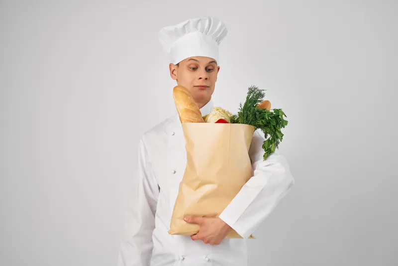 Шеф-повар с сумкой для продуктов занимается приготовлением пищи и обслуживанием