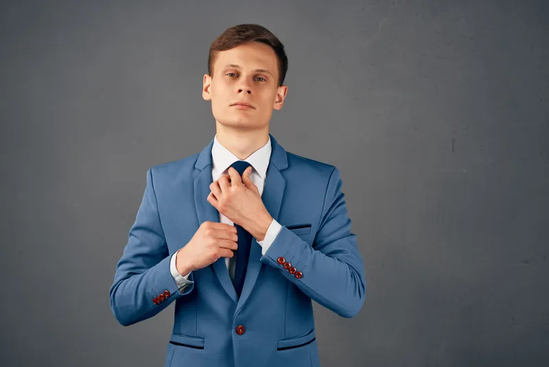 Деловой мужчина в костюме поправляет галстук