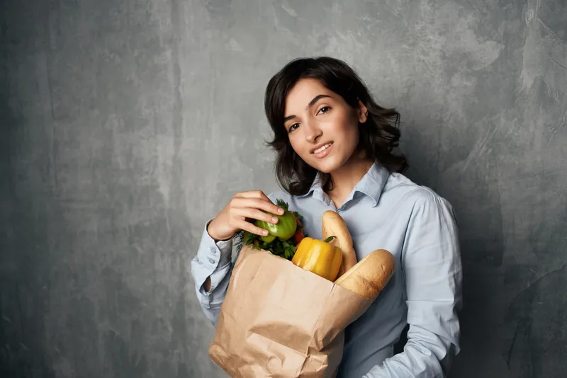 Женщина с пакетом продуктов, овощи, здоровая пища на тёмном фоне
