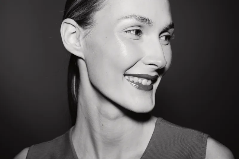 Close up of smiling Caucasian woman with fair skin looking aside. Portrait in black and white with soft lighting and natural expression.