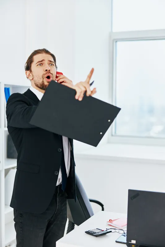 Мужчина в костюме с официальными документами работает в офисе с использованием технологий