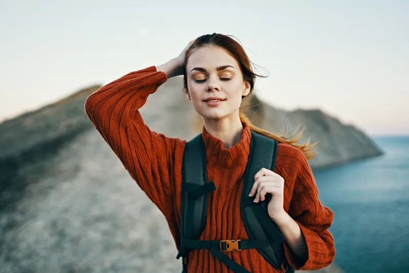 Высокие горы, холмы и счастливый путешественник на природе у моря