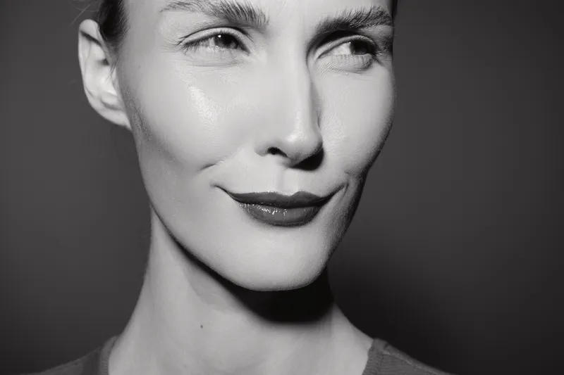 Close-up portrait of a smiling white woman with fair skin and short hair in black and white. Concept of natural beauty, confidence, and facial expression.
