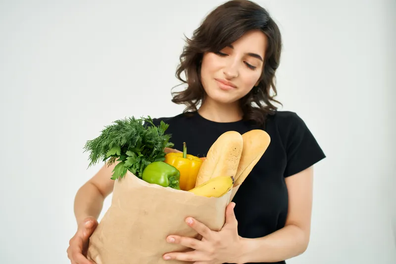 Женщина в черной футболке с пакетом продуктов, здоровая пища, домашняя работа