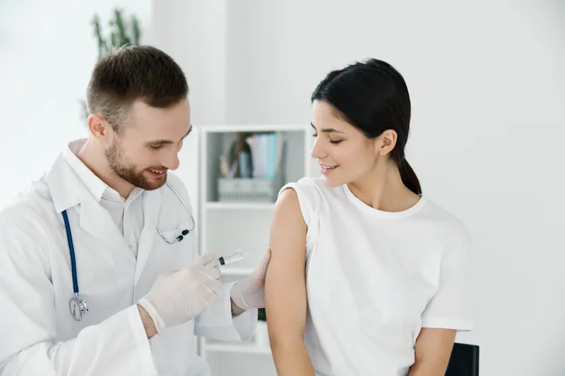 Врач делает женщине укол в плечо вакцинация эпидемия больница