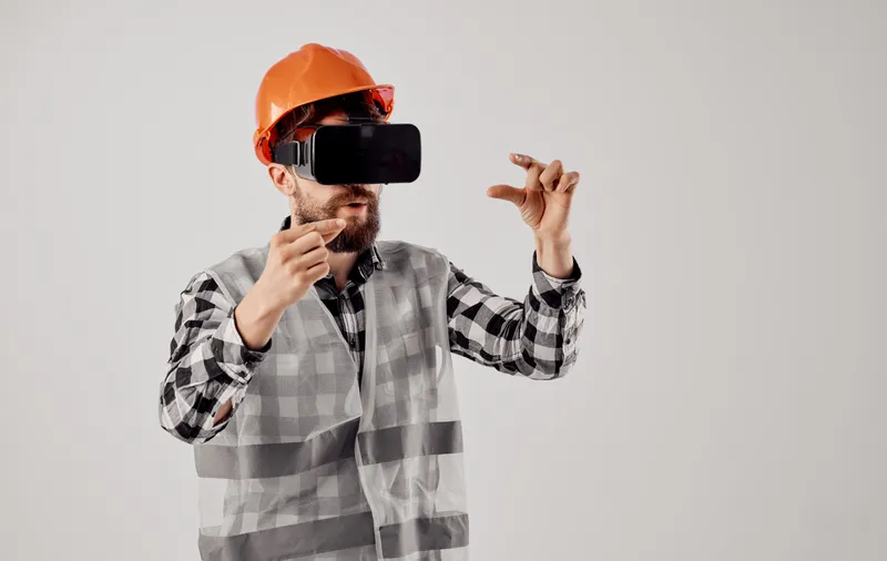 Инженер-строитель в 3D-очках виртуальной реальности и оранжевой каске на голове