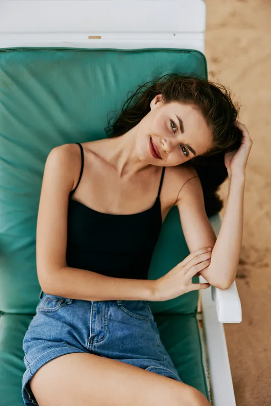 Женщина отдыхает на шезлонге на пляже