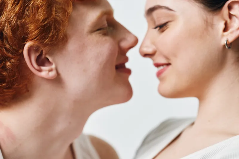 Couple with close faces smiling gently with eyes closed for love, intimacy, connection, affection and trust in relationship and romance moment at home indoors.