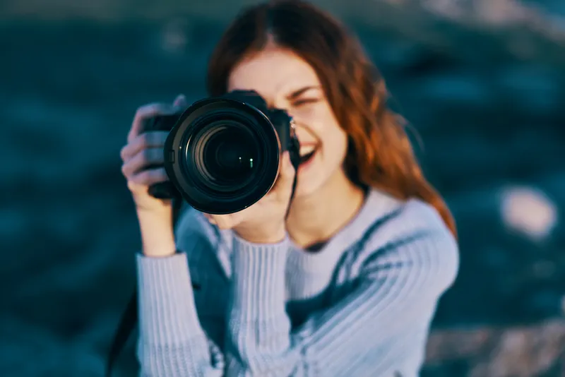 Крупный план симпатичной женщины-фотографа на природе среди скалистых гор, профессиональный вид