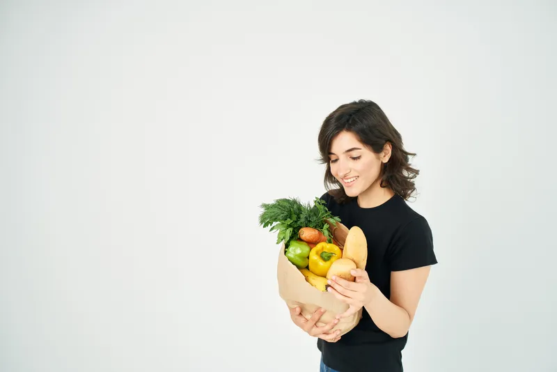 Весёлая женщина с пакетом продуктов, доставка овощей