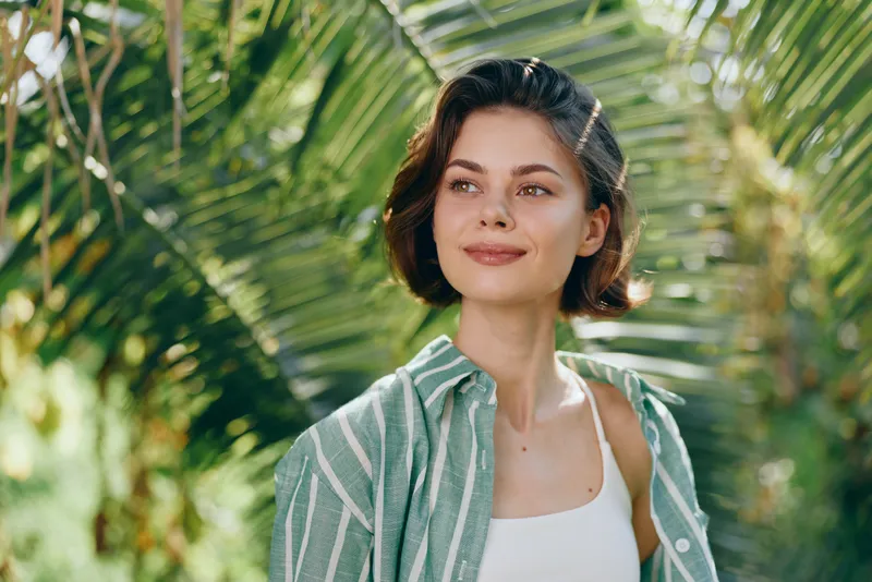 Woman, portrait, outdoors, sunny, greenery, smiling, confident, casual style, relaxed pose, natural light, fresh air, fashion vibe, serene mood, tranquil setting, effortless charm, everyday beauty,