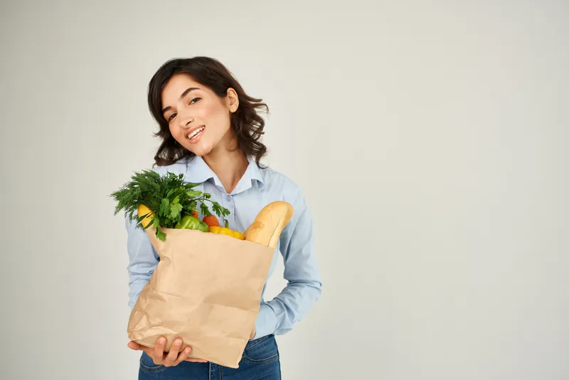 Женщина с пакетом овощей и продуктов из супермаркета, крупный план