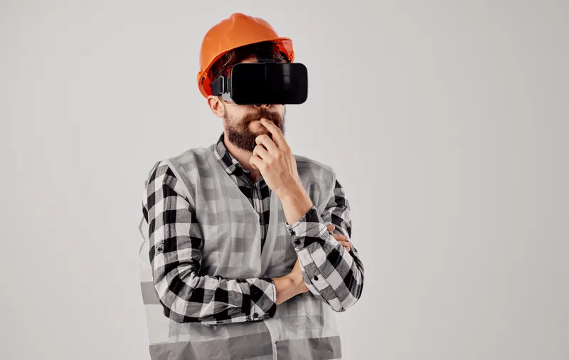 Инженер-строитель в 3D-очках виртуальной реальности и оранжевой каске на голове