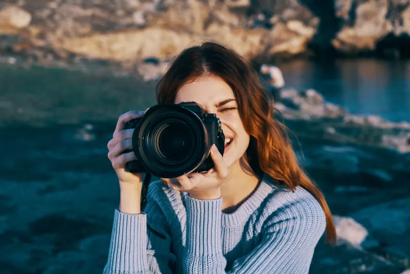 Женщина-фотограф на фоне скалистых гор, путешествие, отпуск, свежий воздух