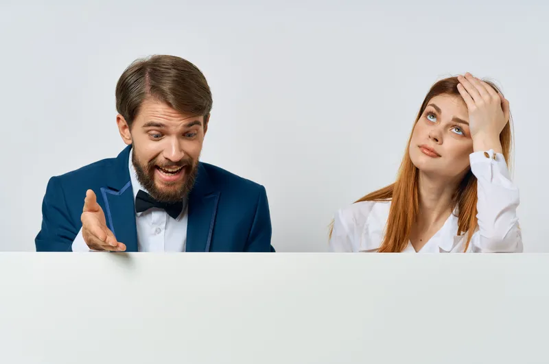Деловой мужчина и женщина держат белый рекламный плакат-макет