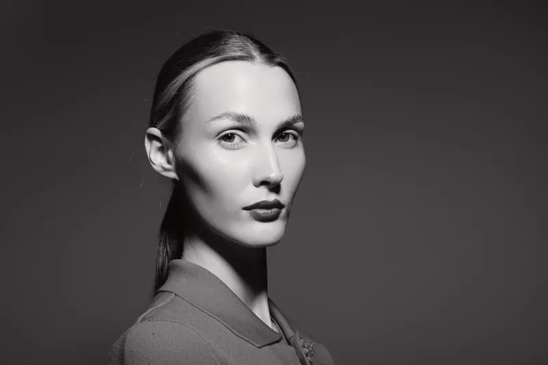 Portrait of a Caucasian woman with fair skin and slicked back hair in studio lighting. Concept of elegance and minimalism.