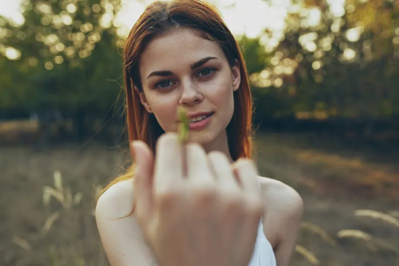 Красивая женщина держит богомола на природе