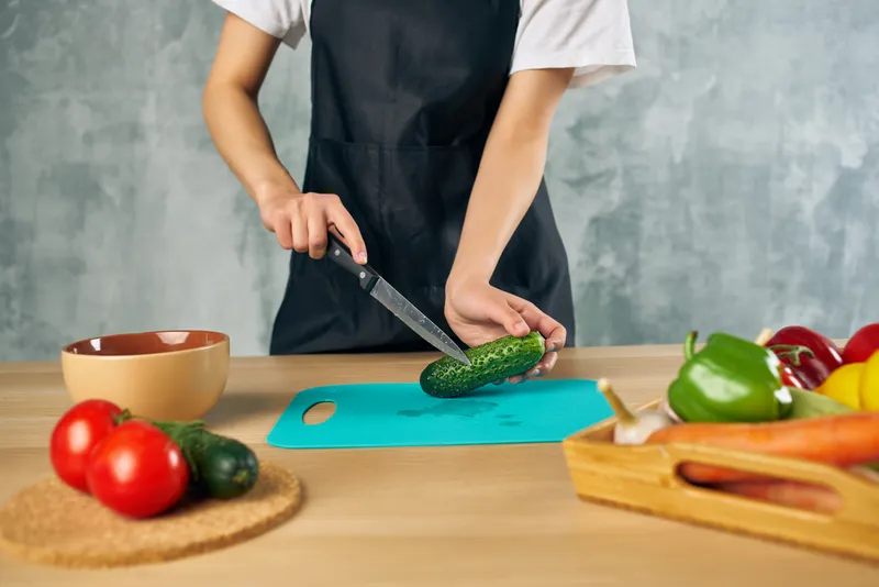 Домохозяйка на кухне нарезает овощи для салата, диетическое питание