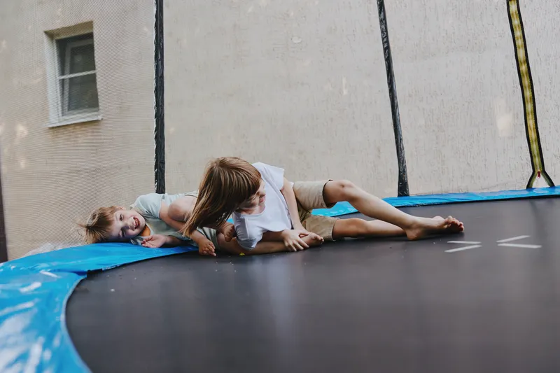 Energetic children playing on a trampoline, enjoying laughter and fun while demonstrating carefree joy. Their delighted expressions capture the essence of childhood happiness.