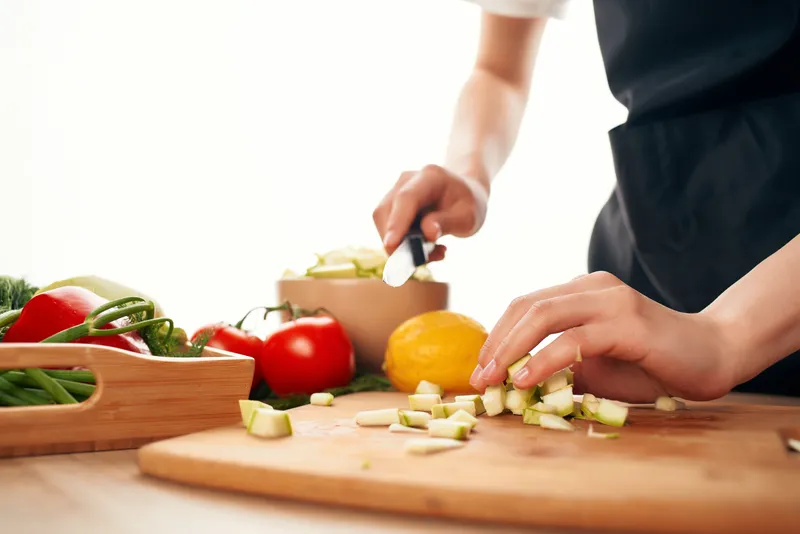 Нарезка свежих овощей и приготовление салата на кухне: свежие продукты