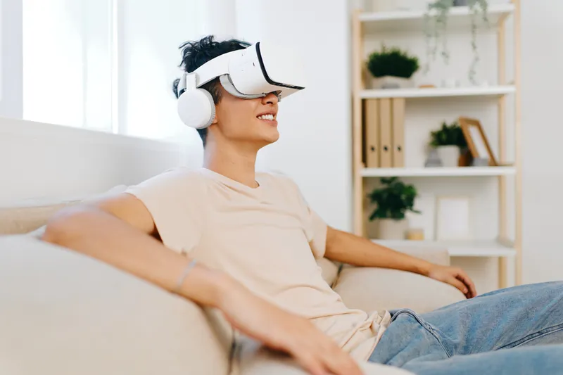 Молодой человек погружен в опыт виртуальной реальности: на нем VR-гарнитура и наушники