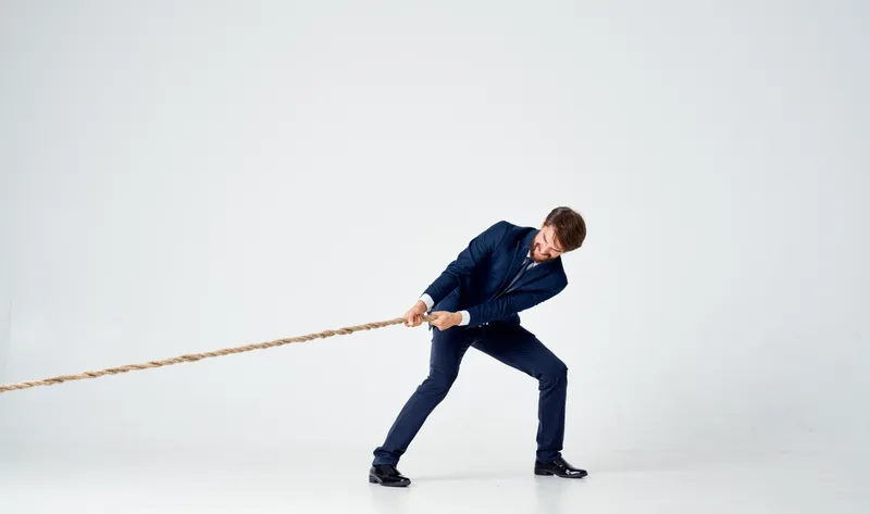 Деловой мужчина в костюме танцует в студии на светлом фоне, работая законодателем